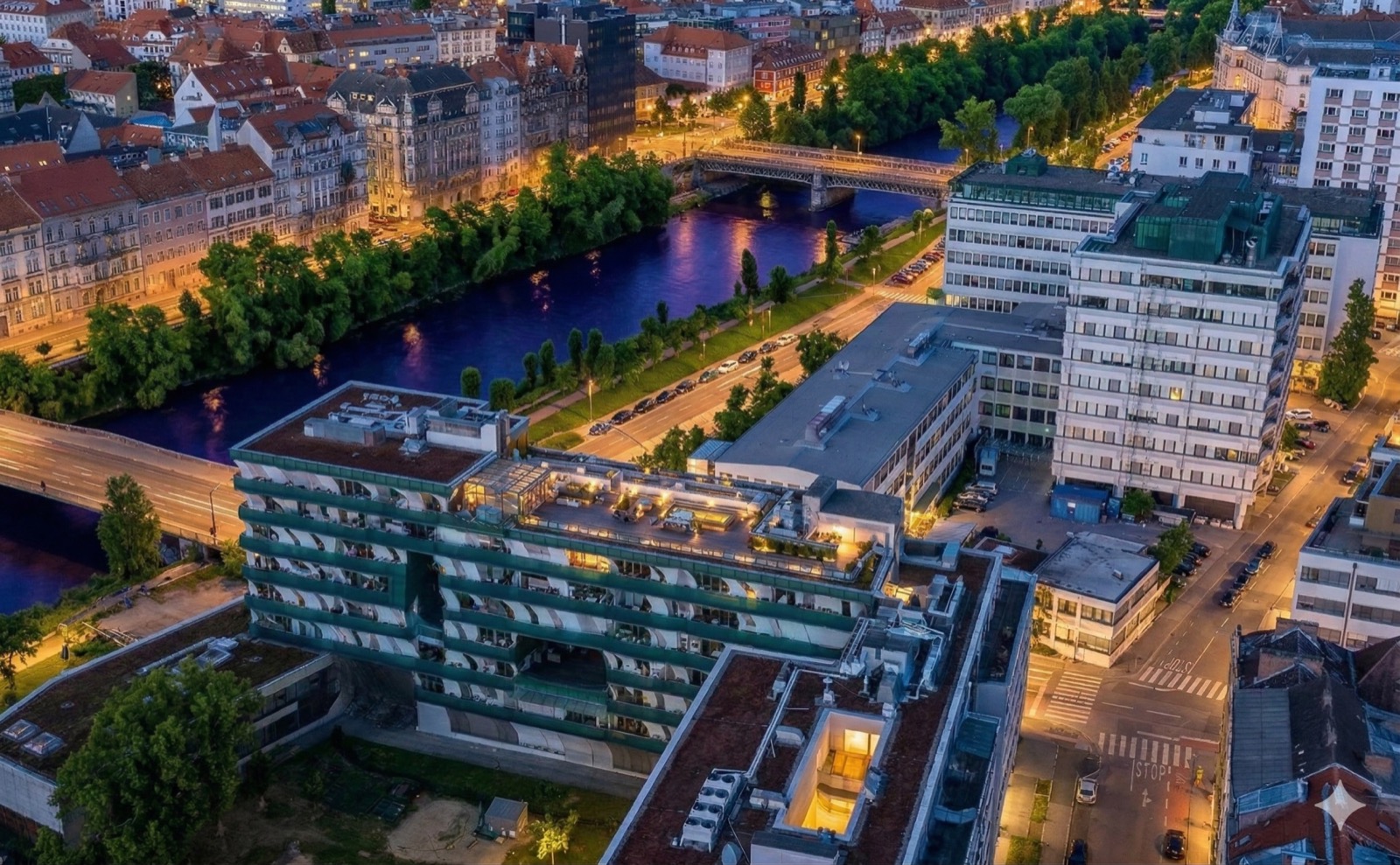 Stadtpanorama mit Wohngebäuden und Mur bei Abendlicht